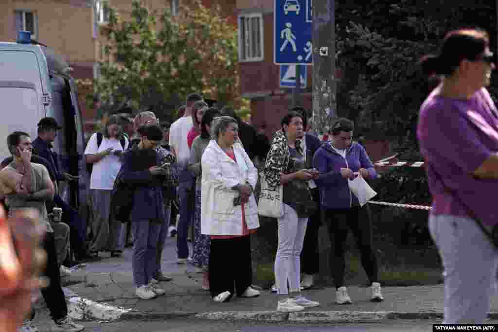 Residents gather outside the damaged apartment building in Ramenskoye following the drone attack. Russia's Defense Ministry reported that over 70 drones were downed in the Bryansk region, with dozens more intercepted in other areas. No damage or casualties were reported in these regions. 