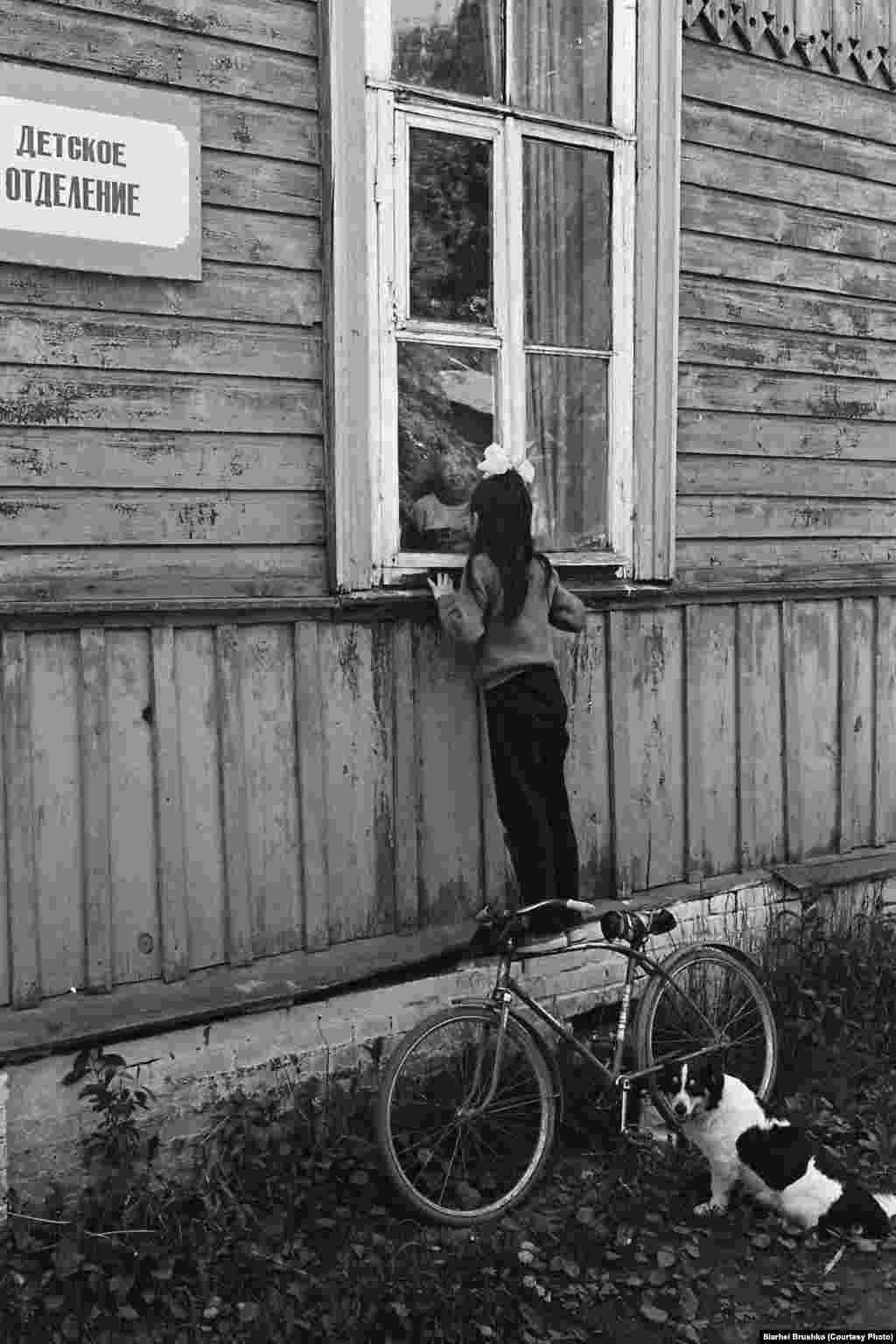 A girl looks into the window of a children's hospital, 1988.