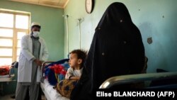 A doctor talks with a patient and her child at the Tangi Saidan clinic run by the Swedish Committee for Afghanistan in the Daymirdad district of Wardak Province.