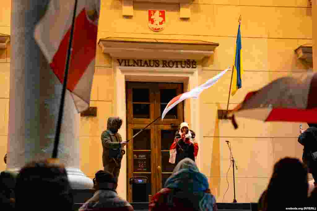 Poems by executed poets are read aloud in Vilnius as Belarusian exiles wave the white-red-white flag, which became a symbol of political activists after Belarus gained independence in 1991. The flag was replaced following a 1995 referendum but was then adopted by anti-government protesters in 2020-21 during demonstrations against authoritarian Belarusian leader Alyaksandr Lukashenka. Protesters who displayed the flag faced arrest in a violent crackdown.