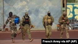 A photograph handed out by French military shows three Russian mercenaries in northern Mali. 