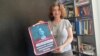 Investigative journalist Nino Zuriashvili with a photo of her face and the caption "There is no place in Georgia for agents."