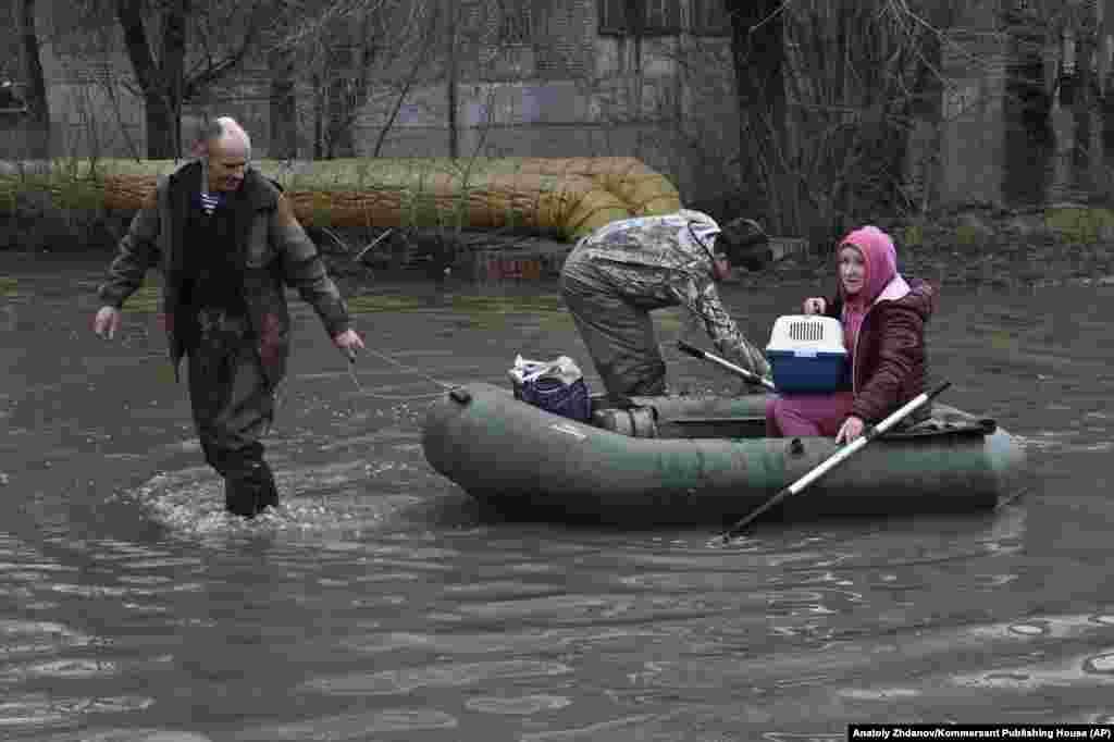 A woman and her cat are pulled to safety. Over 4,000 people, including 800 children, were forced to evacuate their homes in Orsk, the regional government said. 