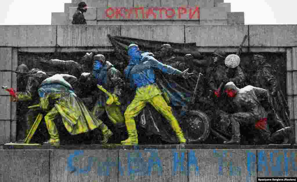 The oft-attacked panel of the Sofia memorial painted in the colors of the Ukrainian flag on February 27, 2022. Graffiti at the top of the image reads: “Occupiers.”