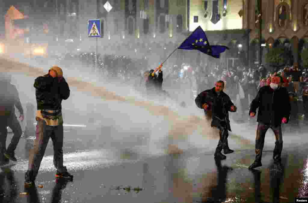 Полиция использует водомет против участников митинга. Фото — Irakli Gedenidze (Reuters).