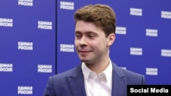 Ilja Medvedev, sin bivšeg ruskog predsednika Dmitrija Medvedeva, stoji ispred panoa s imenom vladajuće stranke Jedinstvena Rusija.