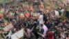 Supporters gather around a car carrying Pakistan's former Prime Minister Imran Khan (not pictured) after he appeared at a court in Islamabad on February 28.