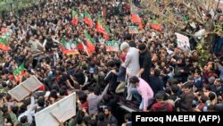 Supporters gather around a car carrying Pakistan's former Prime Minister Imran Khan (not pictured) after he appeared at a court in Islamabad on February 28.