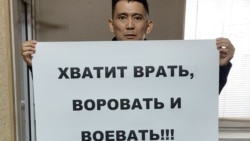 Artyom Burlov holds a placard reading: "Enough Lying, Stealing, And Warring."