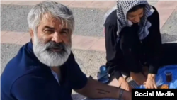 Mashallah Karami and his wife visit their son's grave.