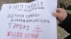 Kirill Voitovich holds a sign in Belarusian commemorating victims of Bolshevik persecution.