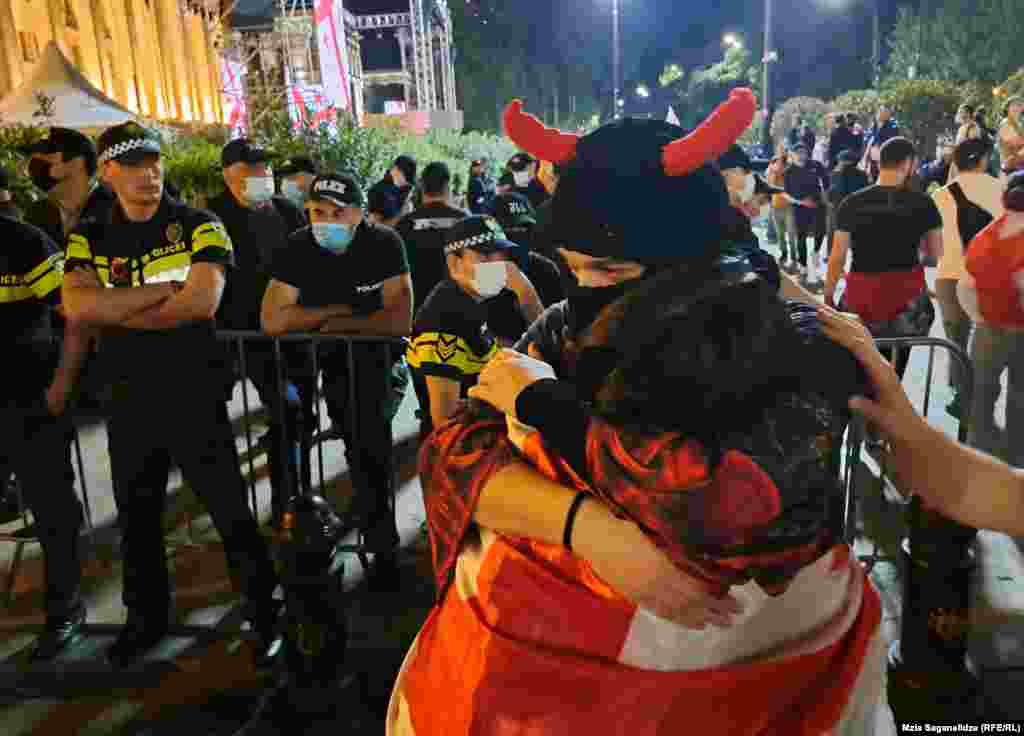 People embrace beside a security cordon near the parliament building. The ruling Georgian Dream party announced its plans to reintroduce the bill after a previous version was dropped in 2023. This new version omits the phrase "foreign agent." 