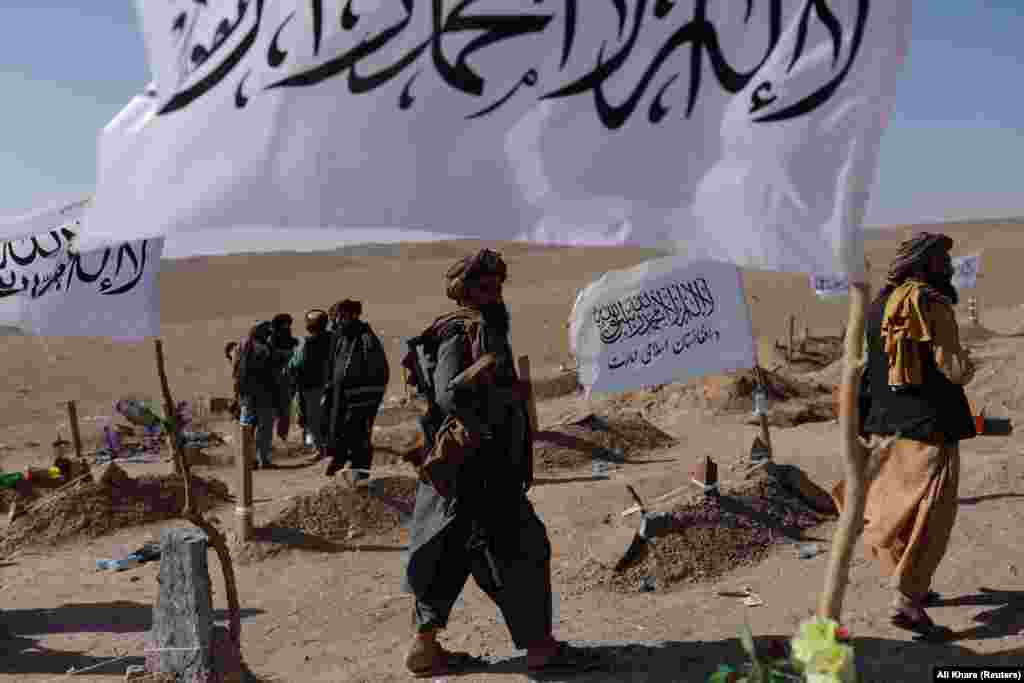 Taliban soldiers walk through a cemetery for victims of the recent earthquake. Neighboring Pakistan has offered assistance but officials in Islamabad said the delivery of its humanitarian aid has been on hold since October 9 as they wait for “clearance” from the Taliban.