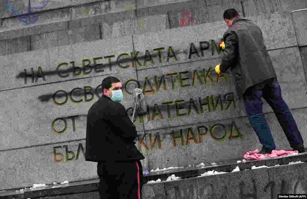 Members of the Bulgarian Socialist Party cleaning the monument after vandals defaced the controversial message of “gratitude” in February 2011.