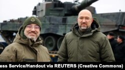 Ukrainian Prime Minister Denys Shmyhal (right) and Defense Minister Oleksiy Reznikov stand next to the first Leopard 2 tanks delivered from Poland on February 24.