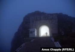 A security guard leaves the fog-bound tunnel of 461 steps that lead from a parking area to the mausoleum on the summit of Mount Lovcen.