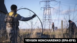 Ukrainian power-engineering specialists try to repair electricity supplies damaged by Russian shelling near the city of Kramatorsk. (file photo)