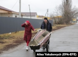 Koporsót szállítanak a helyiek Borogyankában 2022. március 3-án