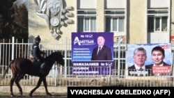 A man rides a horse past campaign posters for candidates in Kyrgyzstan's upcoming parliamentary elections in the village of Arashan, some 25 kilometers south of the capital, Bishkek. 