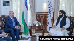Uzbek Foreign Minister Abdulaziz Kamilov (left) meets with acting Foreign Minister Amir Khan Muttaqi in Kabul on October 7.