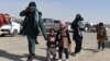 An Afghan migrant family walks in a parking lot before leaving the country in the southwestern province of Nimroz in February. 