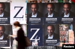 Egy nő sétál el a francia szélsőjobboldali kommentátor, a jövő áprilisi francia elnökválasztás egyik potenciális jelöltjét támogató plakátok előtt Párizsban, Franciaországban 2021. október 13-án