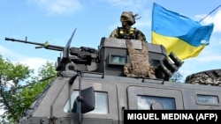 Український військовослужбовець стоїть на верху бронеавтомобіля «Козак-2М» біля Краматорська на Донеччині, 14 липня 2022 року