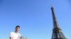 Novak Đoković a Roland Garroson elnyert trófeával pózol a párizsi Eiffel-torony előtt 2021. június 14-én