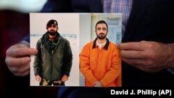 Sami-ullah Safi holds photographs of his brother, Abdul Wasi Safi, as he talks about his brother's journey to the United States during an interview on January 18 in Houston, Texas.