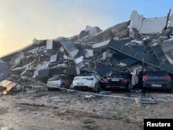 Автомобили под обрушившимся зданием после землетрясения в провинции Хатай. Турция, 7 февраля 2023 года.
