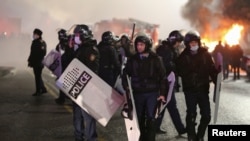 Almatyda protestçilere garşy durýan polisiýa ofiserleri
