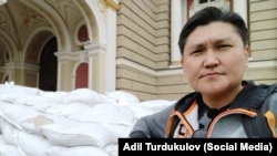 Кыргызстанский журналист, гражданский активист Адиль Турдукулов на фоне Одесского оперного театра (Украина). 