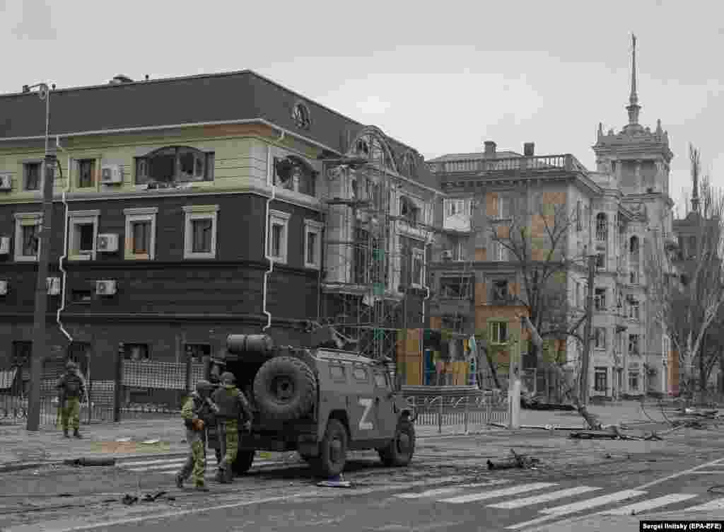 Russian troops unloading an armored vehicle near the Stalinist-era spire house in April 2022. 