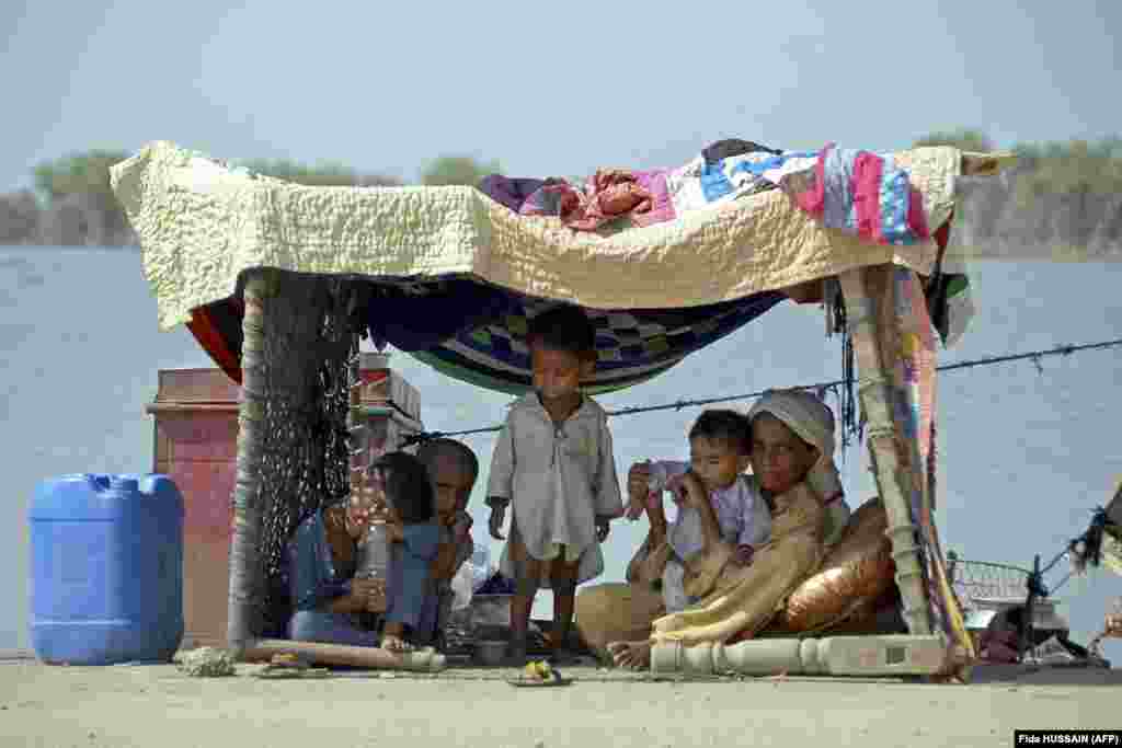 A family who fled to higher ground is photographed in a temporary shelter in the Jaffarabad district on September 19. The massive scale of the flooding is compounding the growing medical crisis as many hospitals remain submerged and unusable. Much of the country's food-growing farmland is also underwater. 