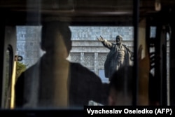 A protester looks at a statue of Lenin in Bishkek in 2021.