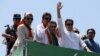 Imran Khan waves as he travels on a vehicle to lead a protest march to Islamabad in Mardan on May 25.