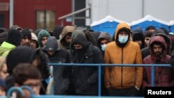 Migránsok gyülekeznek Bruzgi mellett, a szállítási és logisztikai központ közelében a határ belarusz oldalán 2021. november 18-án