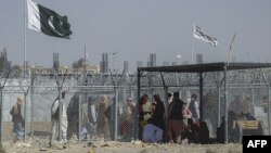 Afghan and Pakistani nationals walk through a security barrier at the Pakistan-Afghanistan border crossing point in Chaman. (file photo)