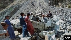 Onlookers gather at the wreckage of a fatal bus crash in Pakistan's Balochistan Province on June 8. 