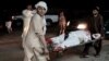Men carry a wounded man on a stretcher outside a hospital following a car bomb in Lashkar Gah on March 23.