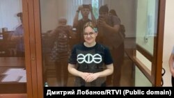 Chanysheva smiles for the cameras from within the defendent's cage at the Basman court in Moscow in July 2022.