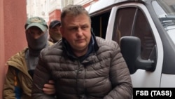 Vladislav Yesypenko, a freelance contributor to RFE/RL, is detained by FSB officers in Crimea on March 16.