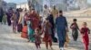 Afghan refugees in Pakistan walk toward the Torkham border crossing with Afghanistan on November 3, following Pakistan's decision to expel people illegally staying in the country.