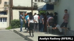 Illýustrasiýa surtay. Aşgabadyň bankomatlarynyň birinde nobata garaşýan adamlar. 