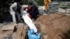 Men bury a victim of the coronavirus at Behesht Zahra cemetery in Tehran on March 24.