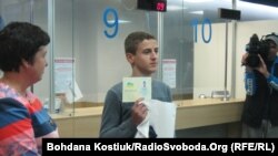 Беженец из региона на востоке Украины показывает выданный киевскими властями паспорт. 28 августа 2014 года.