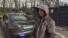 Ukrainian taxi driver Anatoliy Trepak stands next to his recently purchased Tesla in Kyiv.