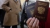 Окупований Крим. Жінка тримає український і російський паспорти біля офісу Федеральної міграційної служби Росії, де вона отримала російський паспорт від окупаційної влади. Сімферополь 7 квітня 2014 року