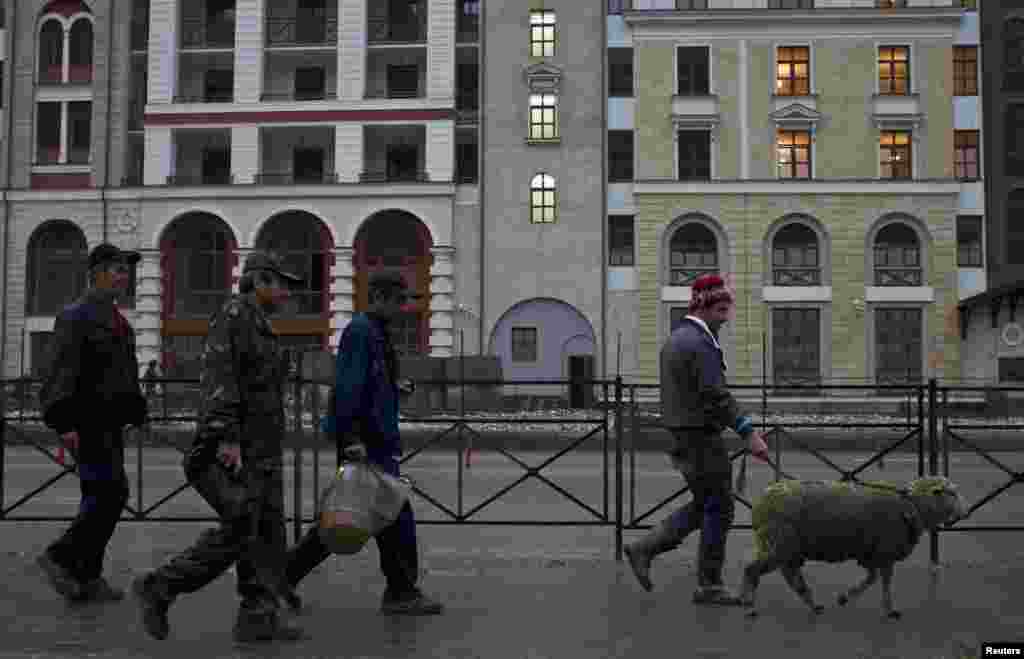 Migrant workers walk with a sheep through the village of Krasnaya Polyana, a venue for the 2014 Winter Olympics some 40 kilometres outside Sochi, in September 2013. 