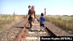 A mother and her children, pictured in 2015, walk across the border from Serbia to Hungary 